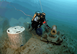 Picture of a diver servicing piezometer ST4-PZ2L-03 by bringing the pressure housing containing the data logger to the sea surface.